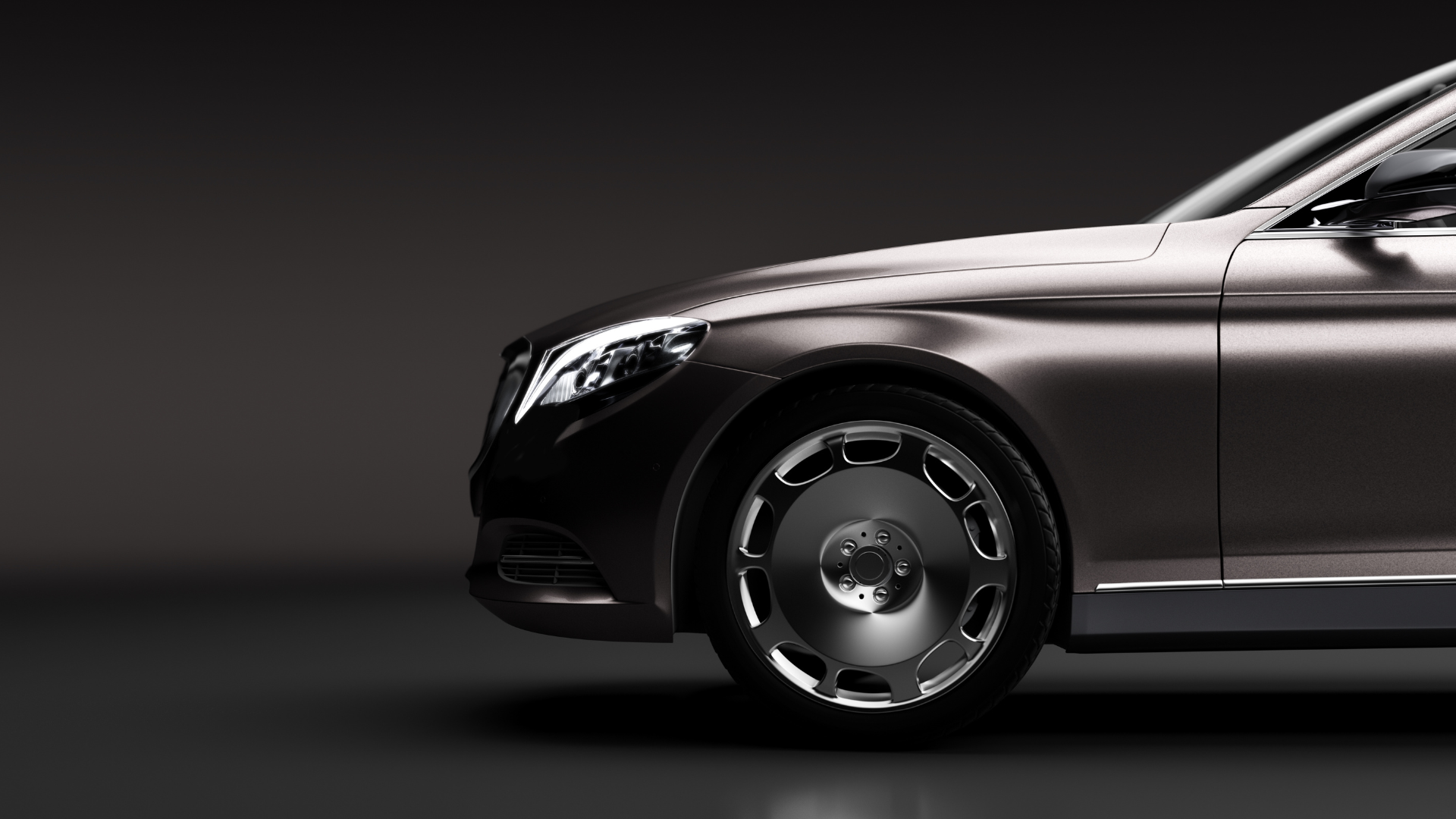 Editorial studio shot of the front quarter of a Mercedes-Maybach S-Class on a dark backdrop